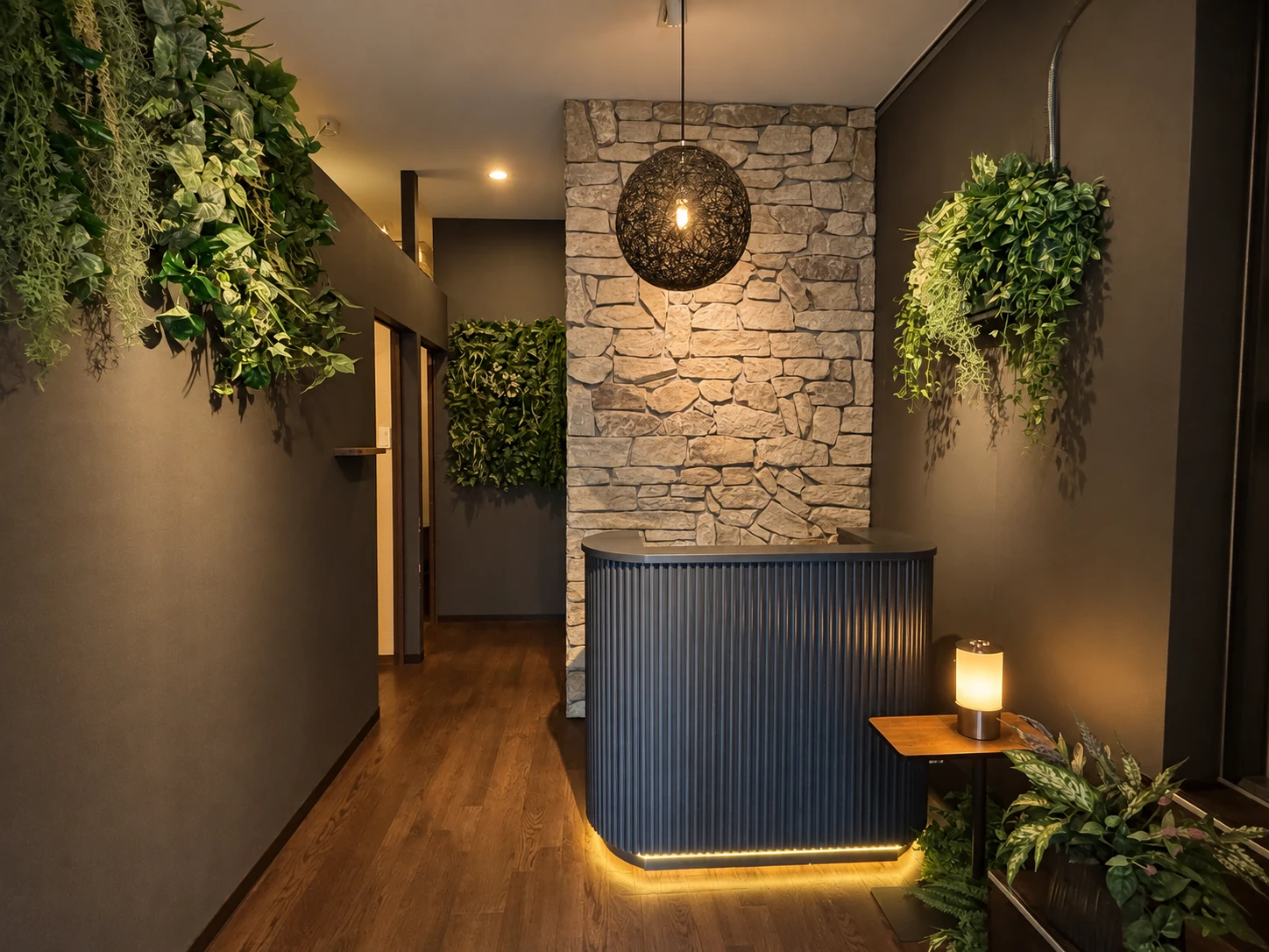 The RYOKUWA reception, with a stone wall, greenery and warm lighting